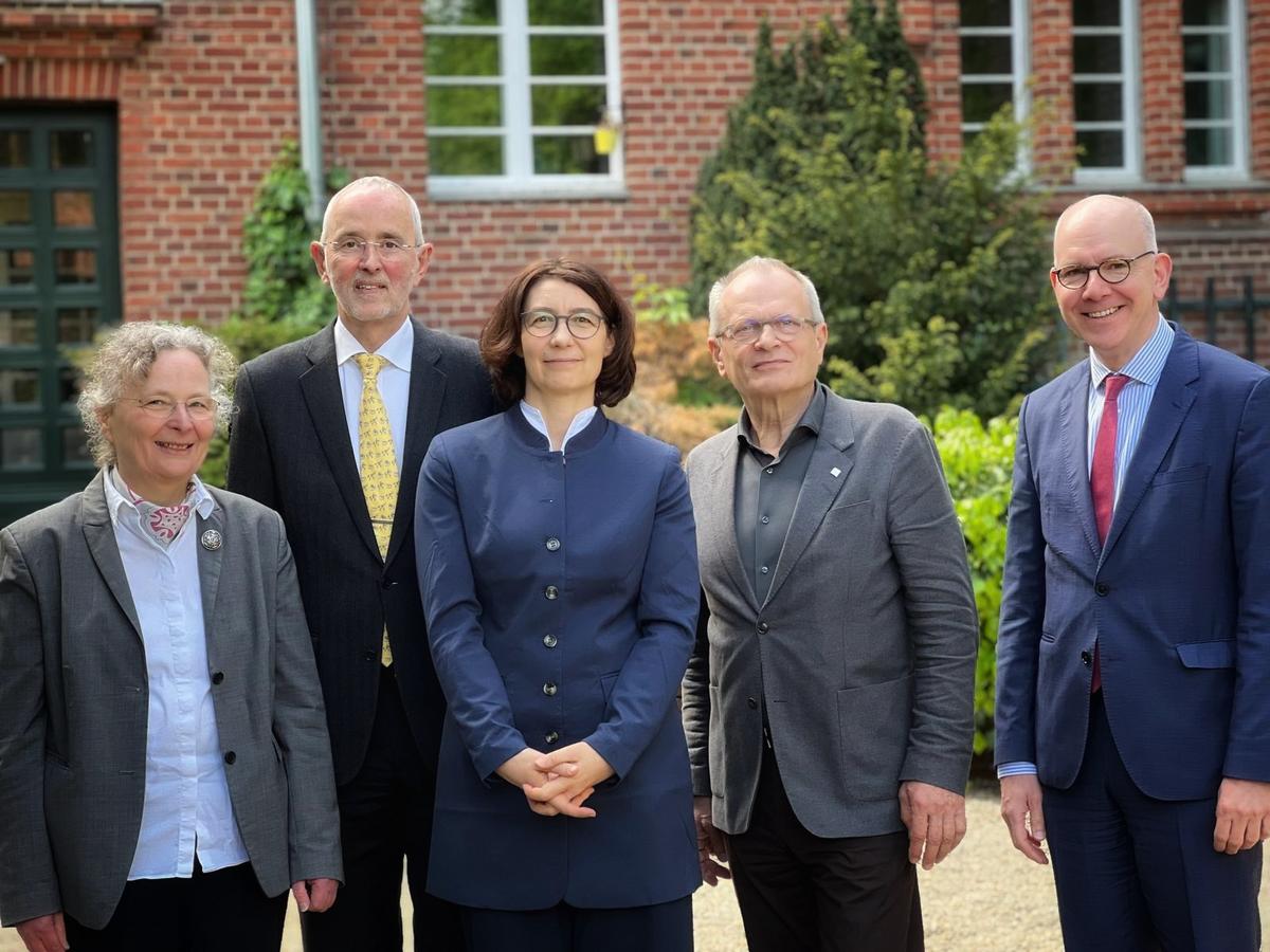 Eine Gruppe von Menschen auf einer Treppe lächeln in die Kamera